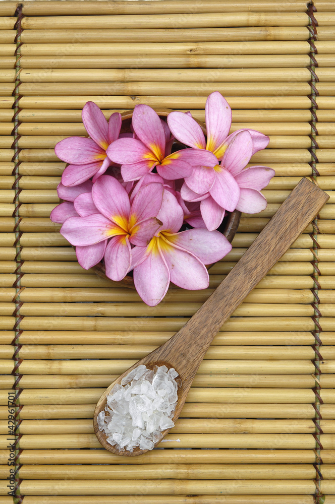 frangipani and Green salt in wooden spoon on mat frangipani and Green salt in wooden spoon on mat