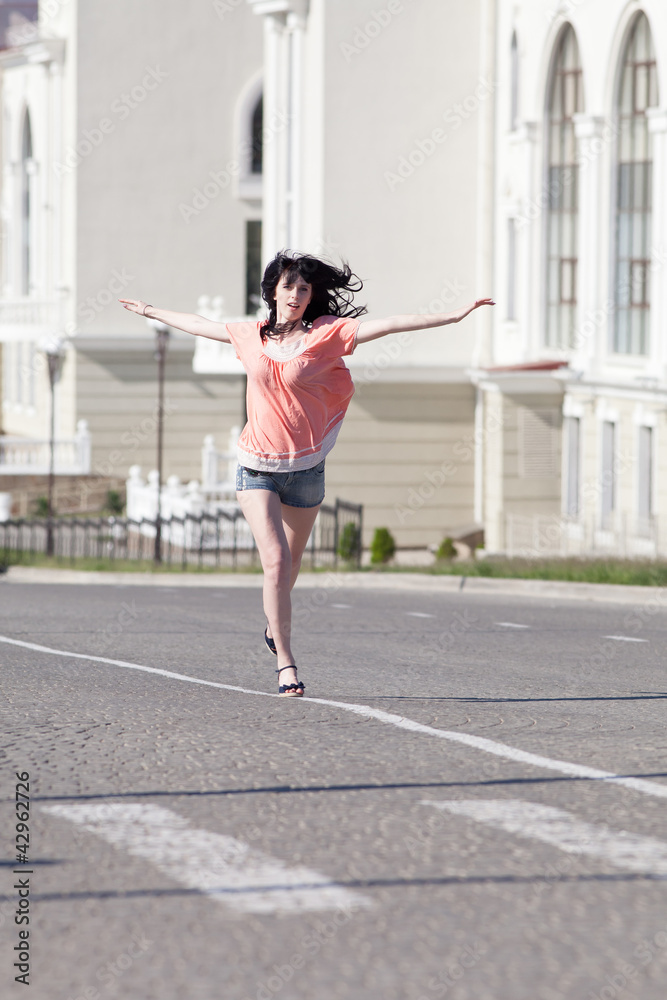 Brunette in shorts running along the carriageway