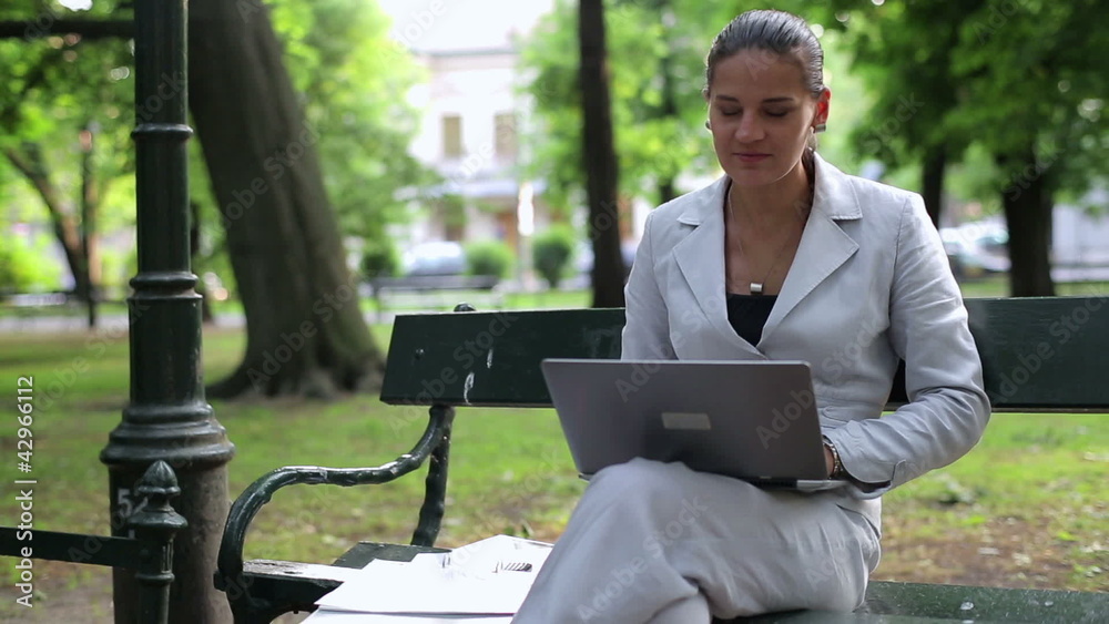 Portrait of happy businesswoman with laptop in the city park Portrait of happy businesswoman with laptop in the city park