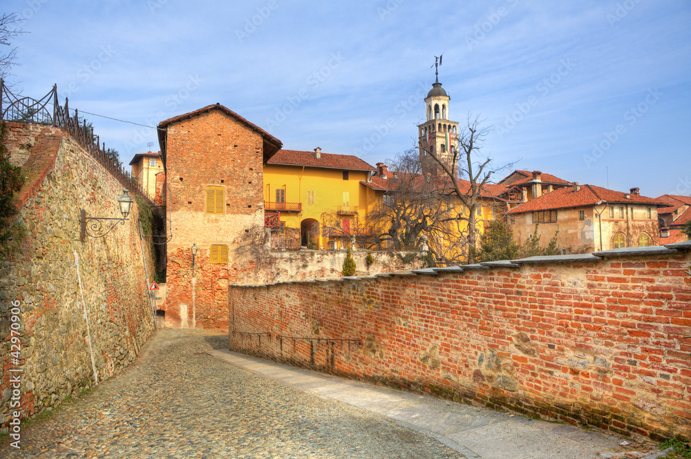 Old houses and paved street in Saluzzo, Italy.