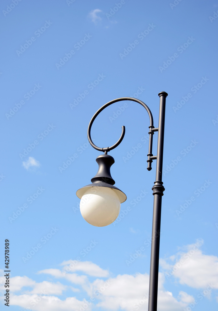 Park round light lamp on pole on background of sky Park round light lamp on pole on background of sky