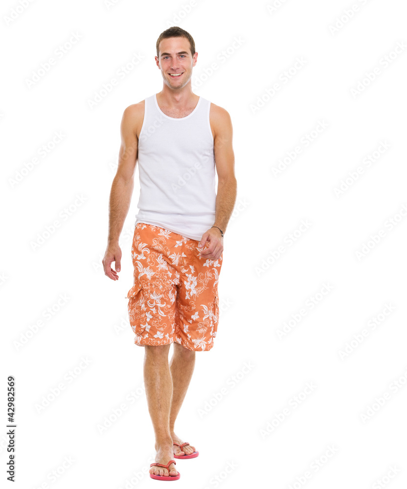 On vacation smiling young man in shorts walking On vacation smiling young man in shorts walking