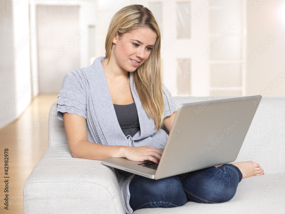 young woman working with notebook, sitting on sofa young woman working with notebook, sitting on sofa