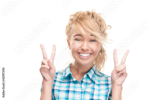 Beautiful and happy young woman making victory gesture.