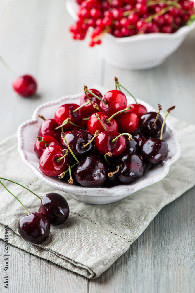 Bowl of black and red cherries (red currants in the background) Bowl of black and red cherries (red currants in the background)