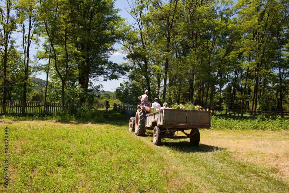 Obraz premium Family of farmers on a tractor