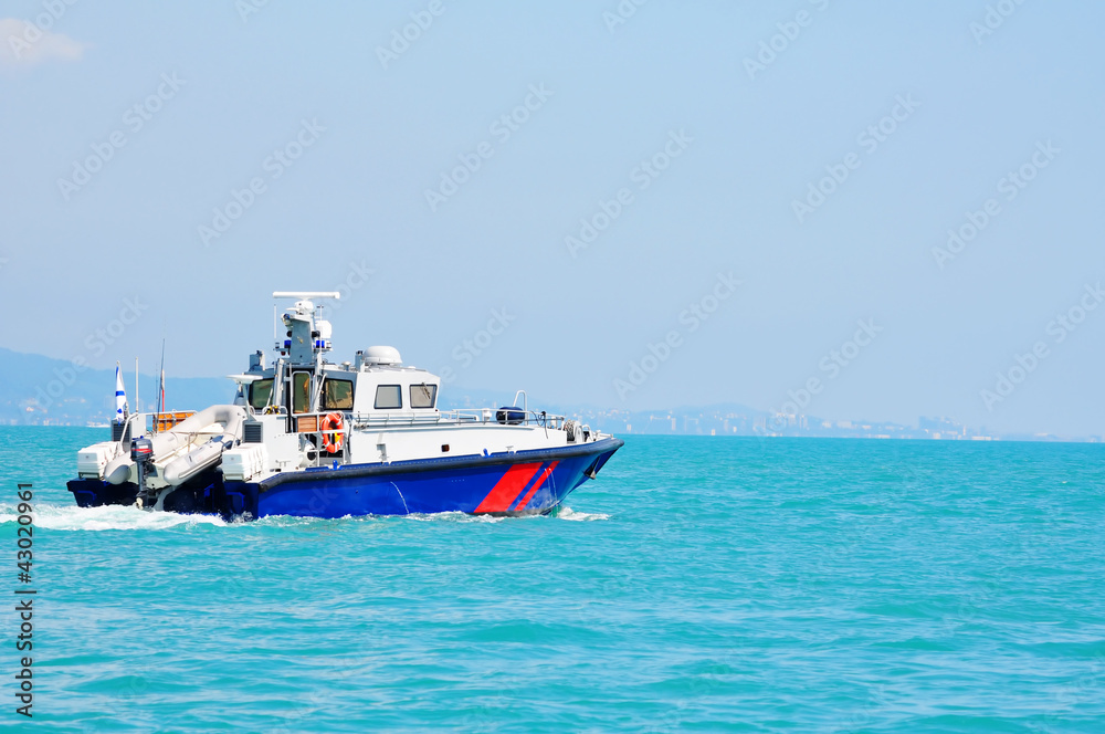 Speedboat with a rubber boat moves along the Black Sea coast Speedboat with a rubber boat moves along the Black Sea coast