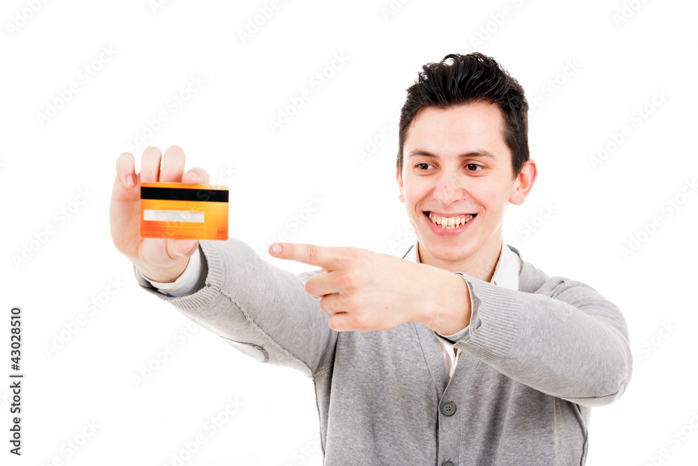 Happy smiling young man holding a credit card and pointing isola Happy smiling young man holding a credit card and pointing isola