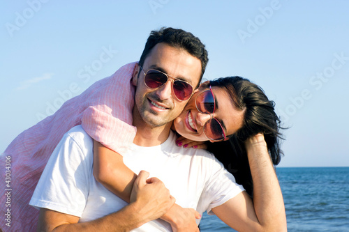Happy couple at the beach in a playful mood