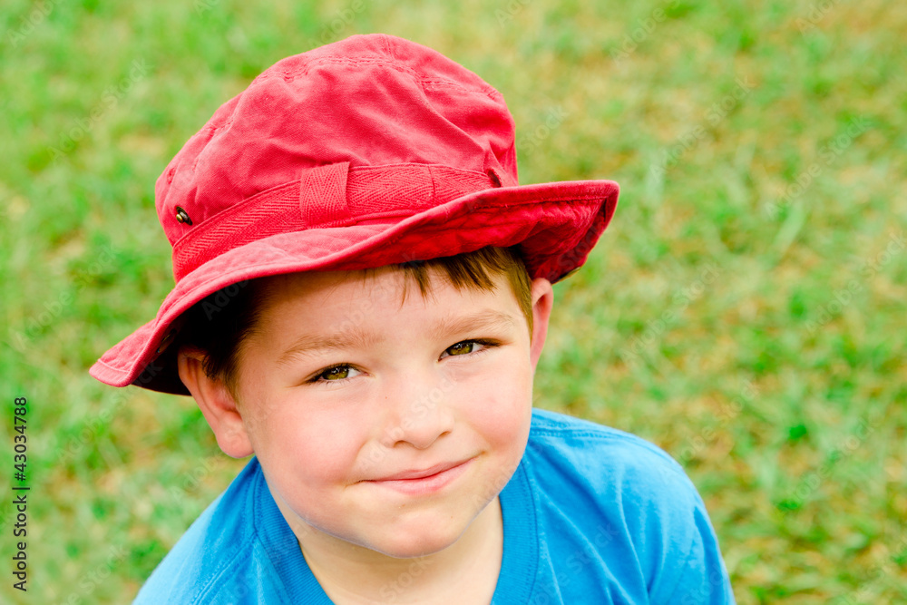Child in summer portrait wearing bright red hat outdoors Child in summer portrait wearing bright red hat outdoors