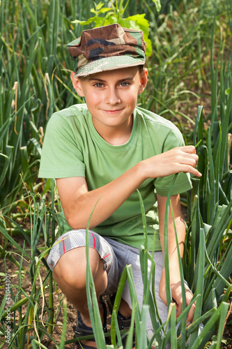 Boy in a lawn of onions