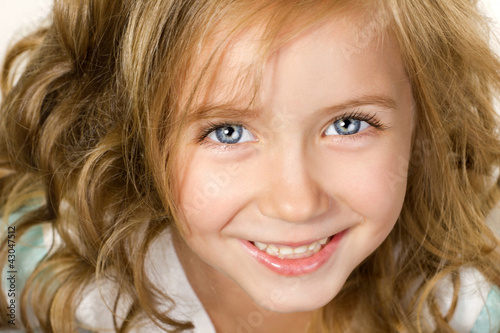close-up portrait big smiling little girl wiht blue eyes