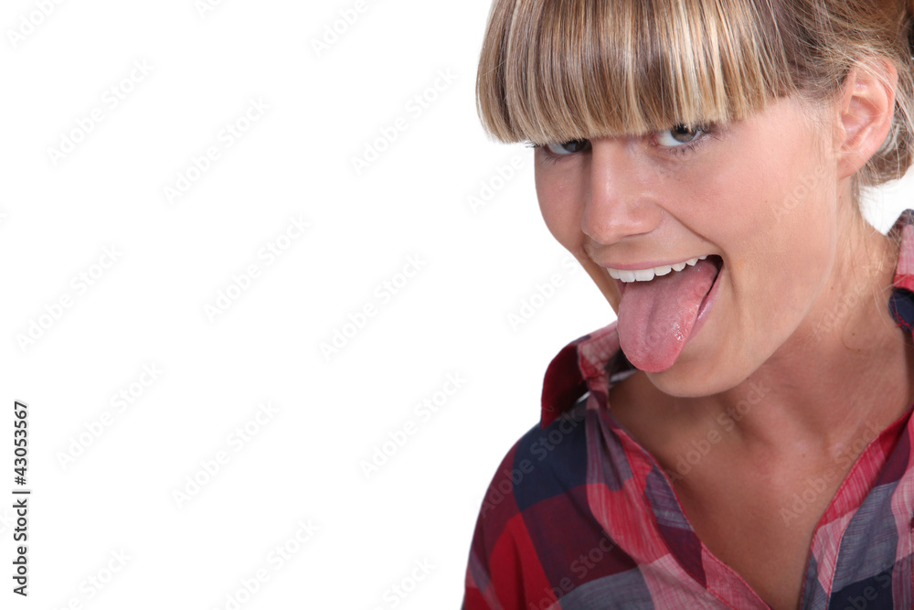 A blond teenager pulling her tongue out. A blond teenager pulling her tongue out.