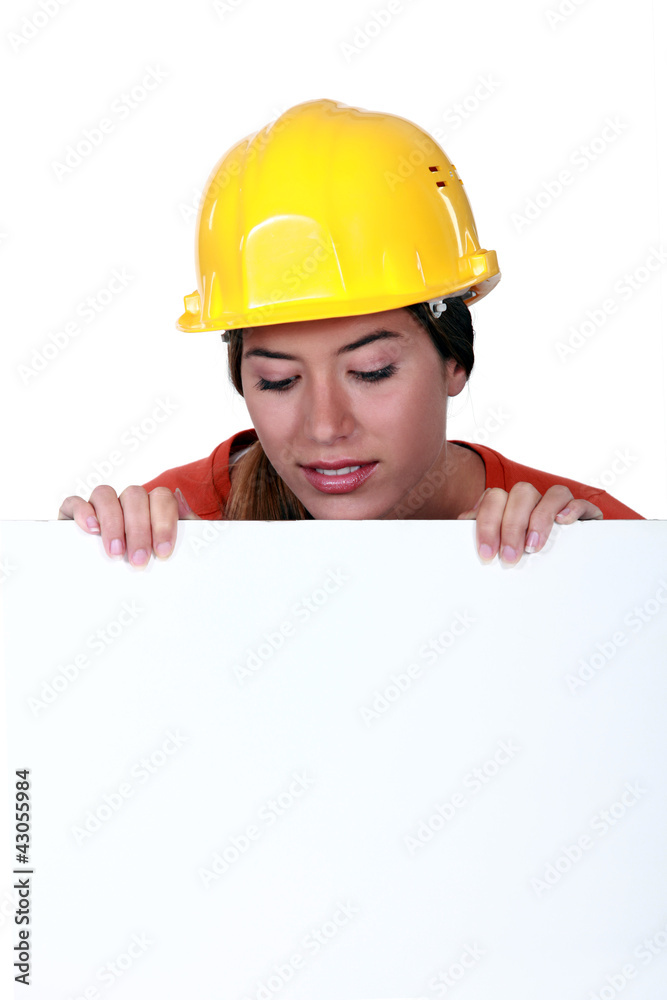 Female laborer behind white sign