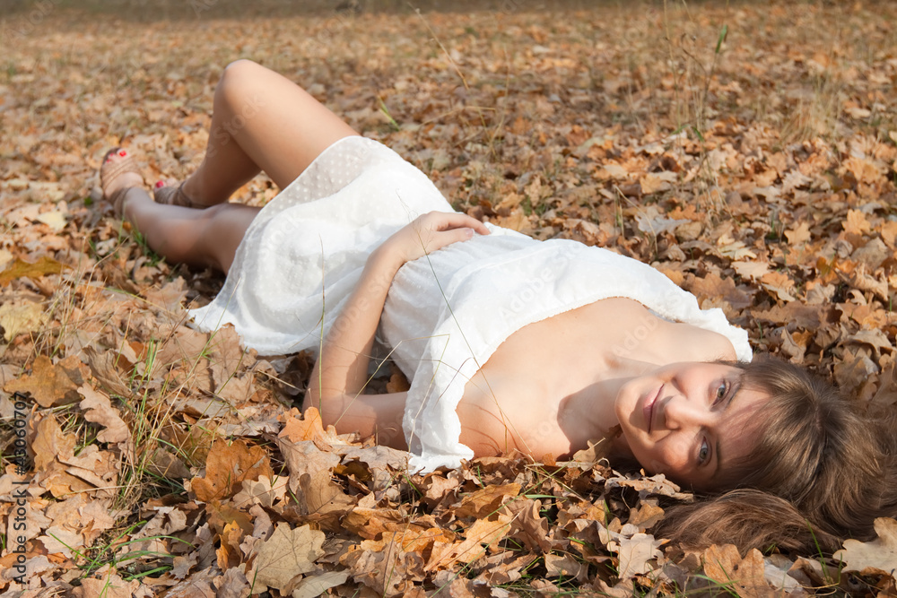 Fototapeta premium girl lies in oak leaves