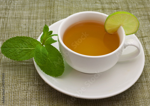 White cup with a branch of mint and limes