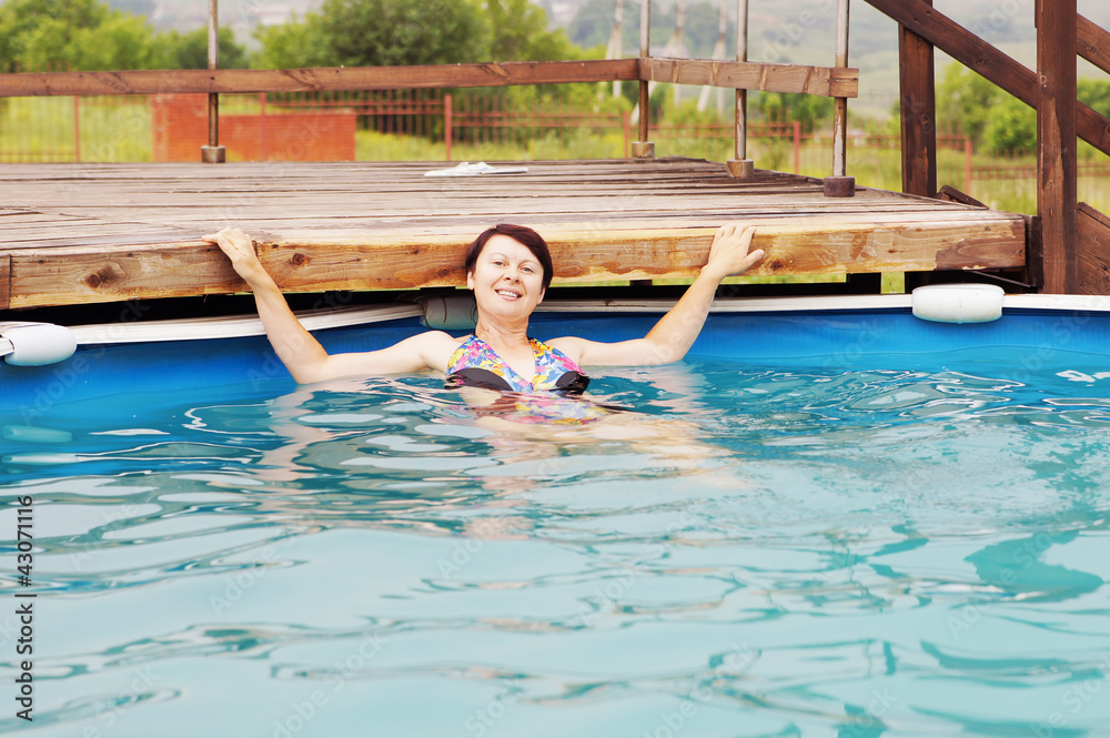 Woman is swimming in an outdoor pool