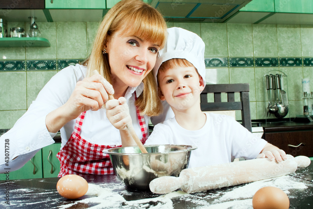 Mother with son baking and cooking in kitchen