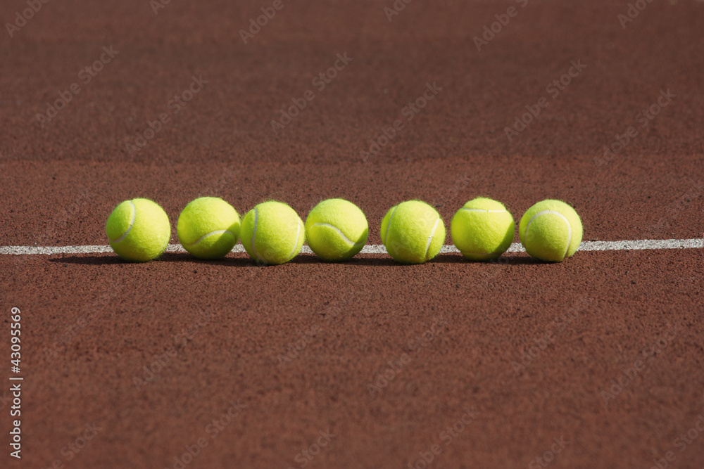 Tennis balls in-line on court in the morning