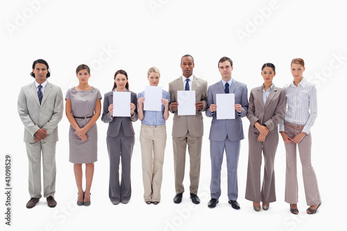 Business people holding four supports for letters