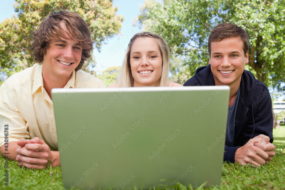 Three smiling students in a park Three smiling students in a park