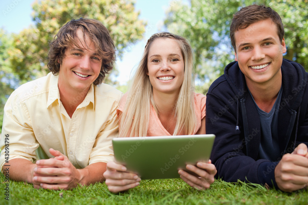 Three smiling students using a tactile tablet Three smiling students using a tactile tablet