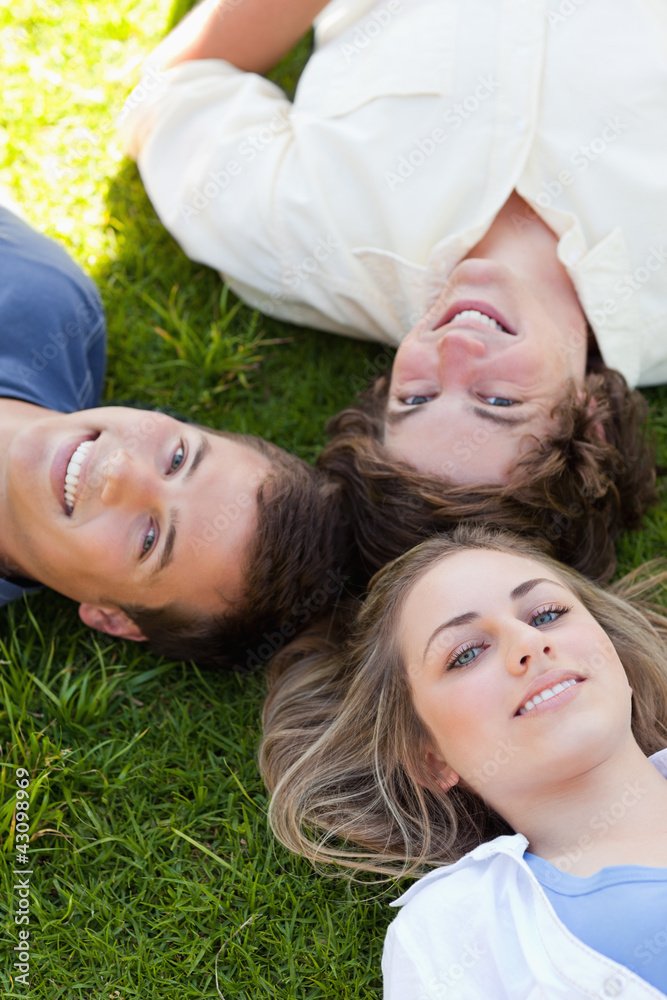 Three students resting together while looking at camera Three students resting together while looking at camera