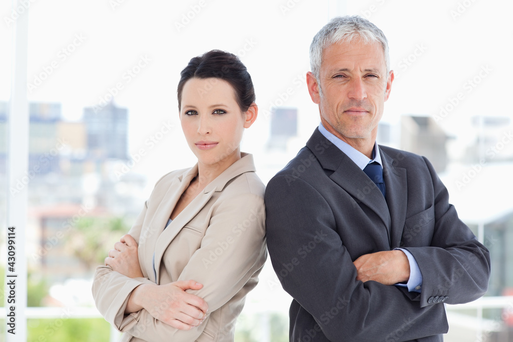 Business people standing upright in front of the window side by Business people standing upright in front of the window side by