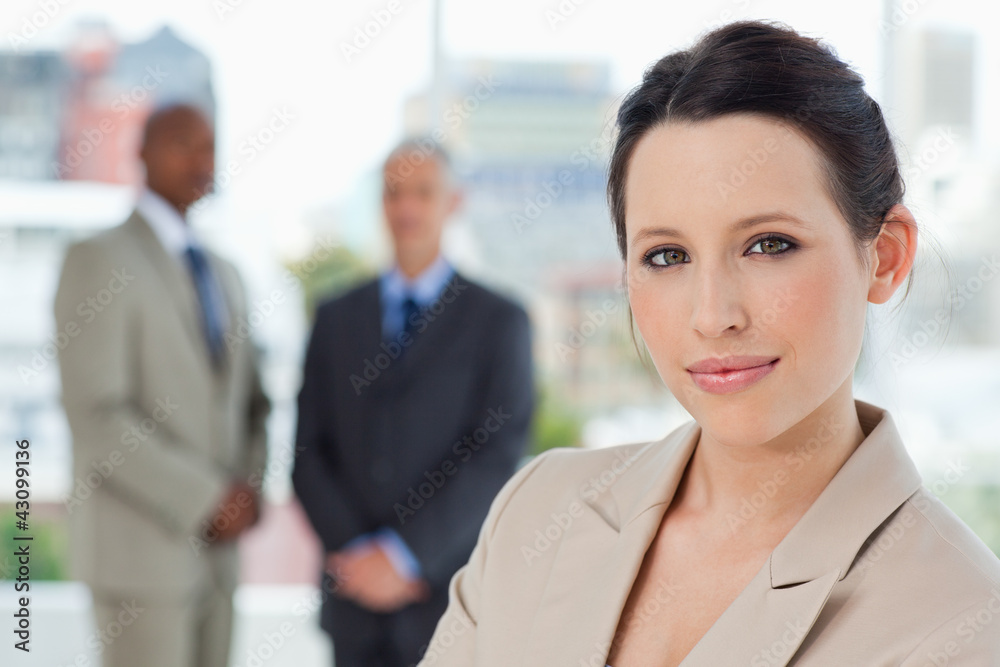 Young secretary standing in front of two executives in a relaxed Young secretary standing in front of two executives in a relaxed