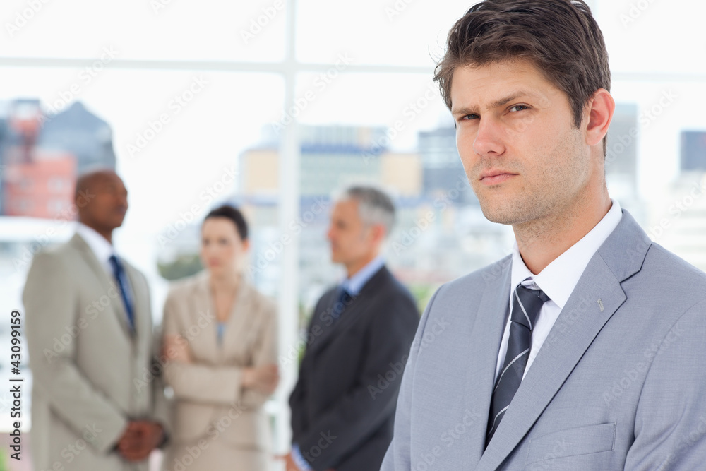 Serious businessman with a stern look standing in front of his c Serious businessman with a stern look standing in front of his c