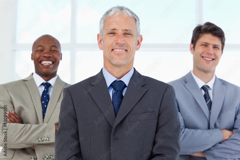 Two young employees standing in the back while laughing and bein Two young employees standing in the back while laughing and bein