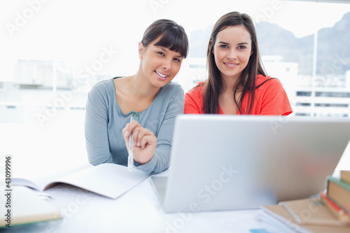 Two girls sitting in front of the laptop while they look into th © WavebreakmediaMicro