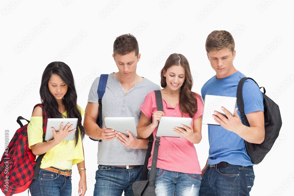 Students with backpacks looking at their tablets Students with backpacks looking at their tablets