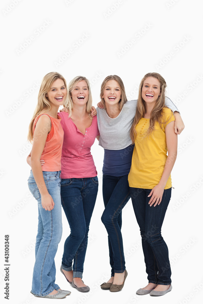 Smiling girls holding each other as they stand beside one anothe Smiling girls holding each other as they stand beside one anothe