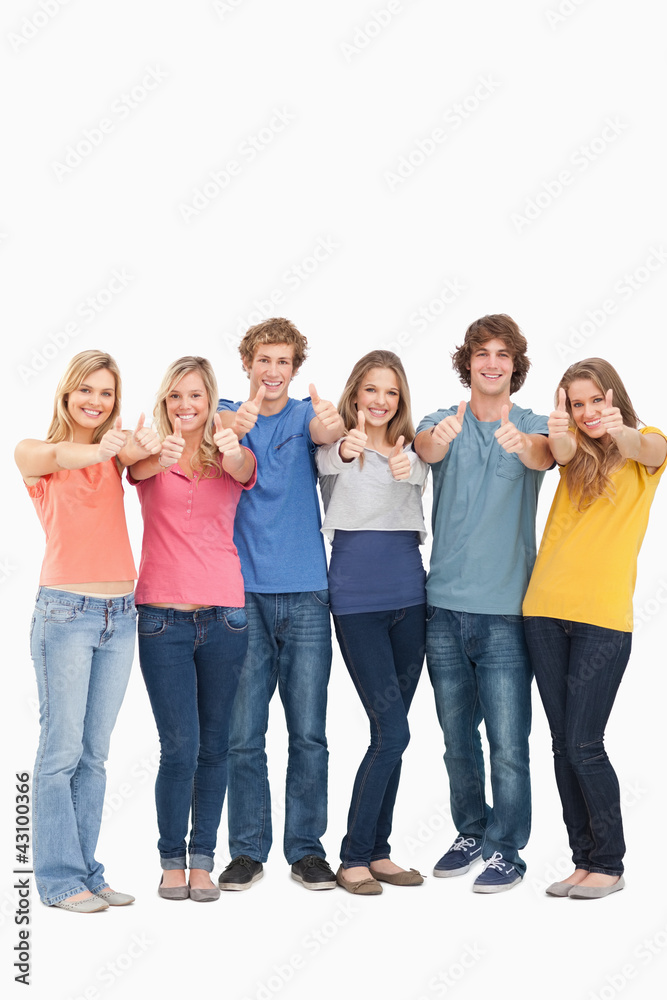 A group smiling and giving the thumbs up