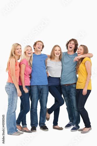 Full length of a group laughing together and looking at the came