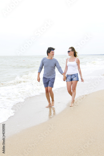 Happy young couple enjoying together at the beach