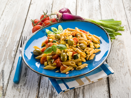 cold pasta salad with pachino olives zucchins and pine kernel