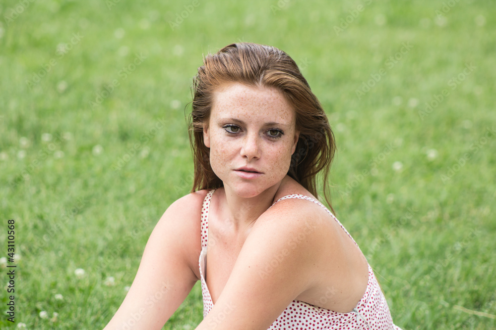 Beautiful girl with red hair, relaxing at campus