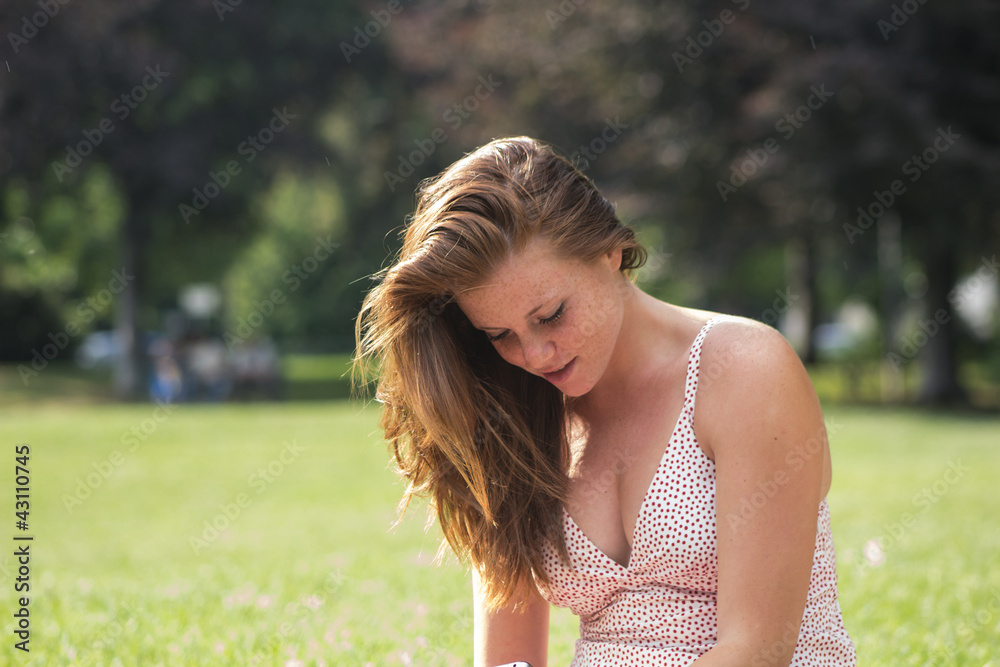 Beautiful girl with red hair, relaxing at campus