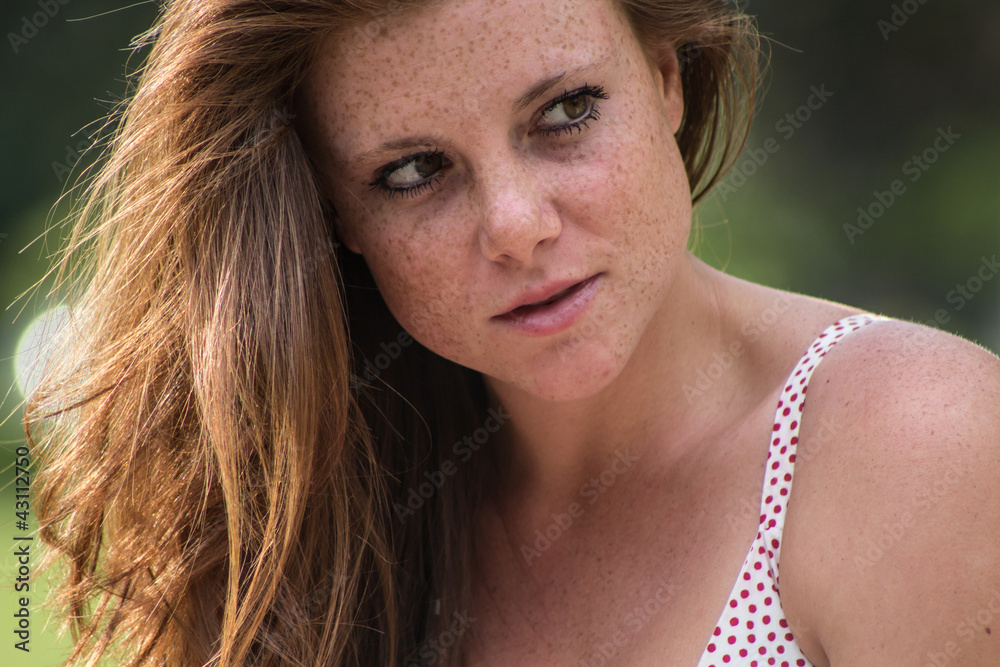 Beautiful girl with red hair, relaxing at campus