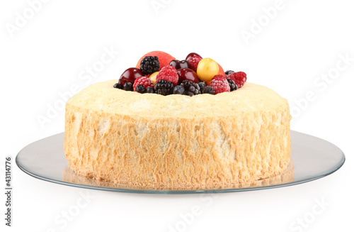 isolated ring cake on glass plate filled with fruits on white