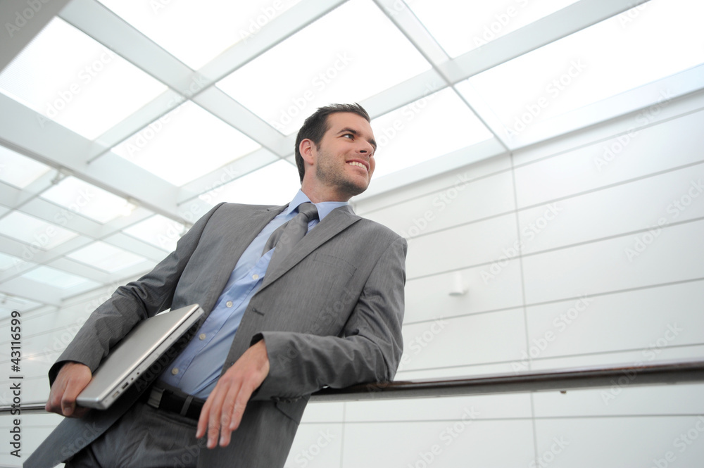 Businessman in grey suit standing in hallway Businessman in grey suit standing in hallway