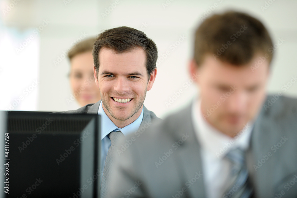 Office worker sitting in front of desktop Office worker sitting in front of desktop