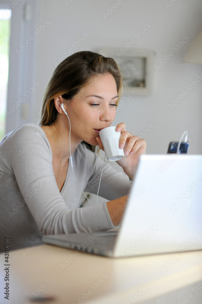 Woman checking email on laptop computer while drinking coffee Woman checking email on laptop computer while drinking coffee