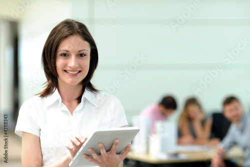Office worker using electronic tablet in on front of group