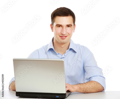 A young man sitting in front of a laptop