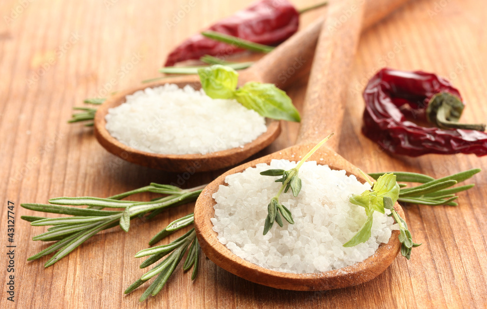 salt in spoons with herbs and vegetables isolated on white salt in spoons with herbs and vegetables isolated on white