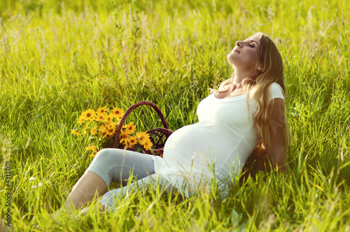 Beautiful pregnant woman relaxing in the park
