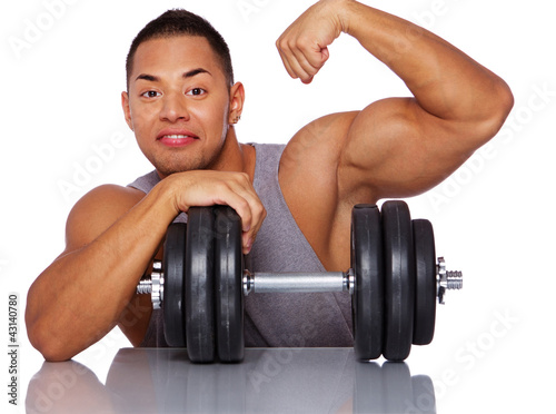 Portrait of muscle man posing in studio with dumbbells